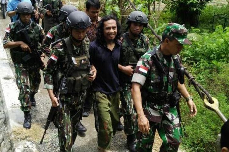 Basri alias Bagong dibawa dengan pengawalan ketat Satuan Tugas Tinombala 2016 di Poso, Sulawesi Tengah, Rabu (14/9/2016). 

