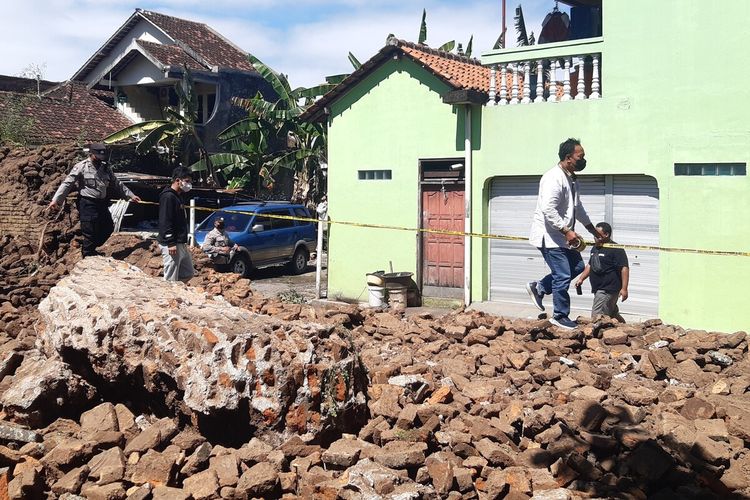 Petugas Polsek Kartasura memasang garis polisi di pagar tembok Ndalem Singopuran RT 002, RW 002 di Desa Singopuran, Kecamatan Kartasura, Sukoharjo, Jawa Tengah yang dijebol, Jumat (8/7/2022).