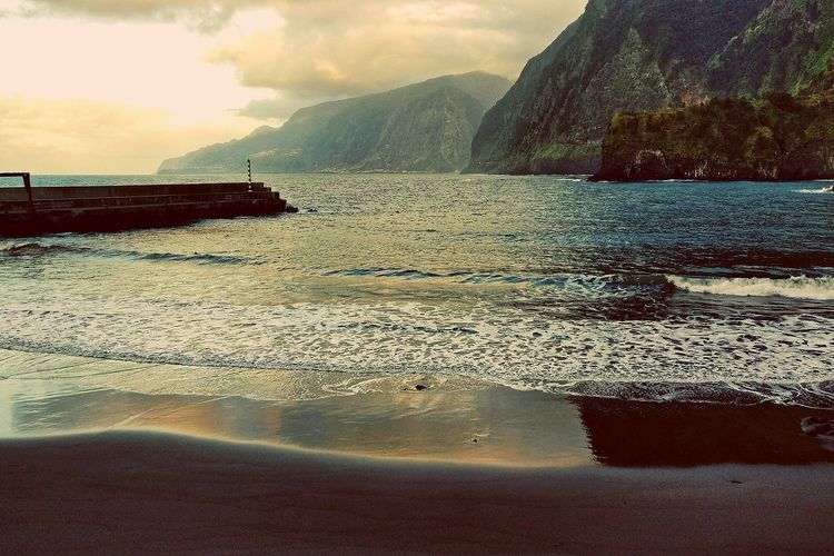 Pantai Seixal (Praia do Porto do Seixal) di Kepulauan Madeira, Portugal, dengan pasir hitamnya.