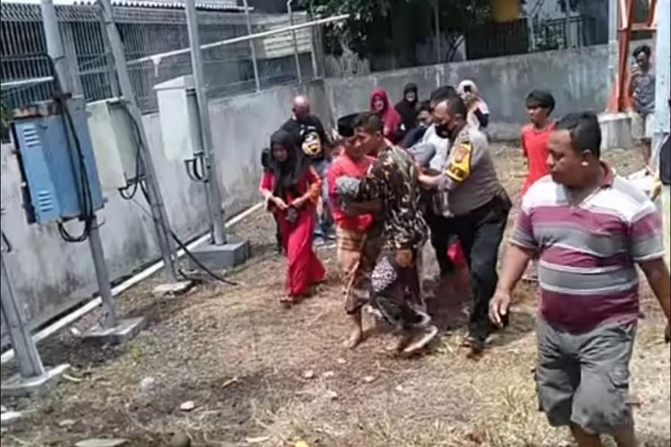 Polisi dan warga membopong A setelah berhasil diturunkan dari menara. 