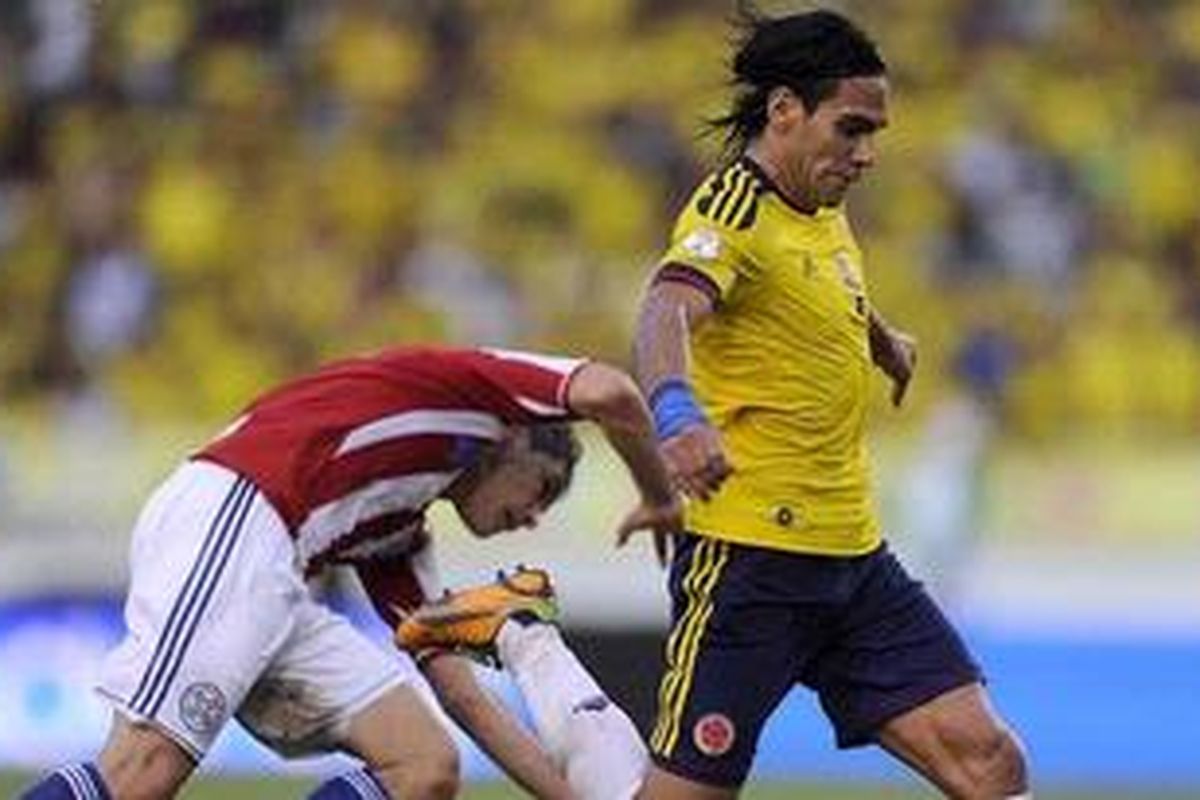 Bomber Kolombia, Radamel Falcao (kanan), dikawal ketat oleh bek Paraguay, Pablo Aguilar, dalam laga penyisihan Pra-Piala Dunia Brasil 2014 Zona Amerika Latin di Stadion Roberto Melendez, Barranquilla, Jumat (12/10/2012). Kolombia menang 2-0.