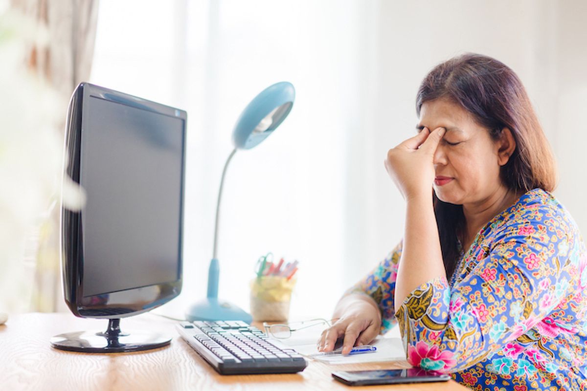 Seseorang yang mengalami zoom fatigue akibat bekerja lama di depan laptop 