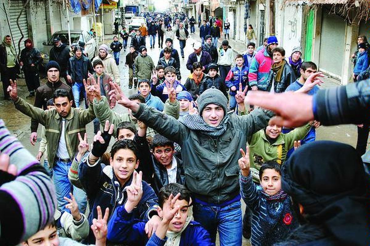 Demonstran antipemerintah mengacungkan tanda kemenangan dalam unjuk rasa di kota resor pegunungan Zabadani, Suriah, tak jauh dari perbatasan Lebanon, Selasa (17/1). Saat para diplomat Liga Arab berdebat, aktivis oposisi mengatakan pasukan Suriah menembaki Zabadani, yang dikuasai anggota militer yang membelot.