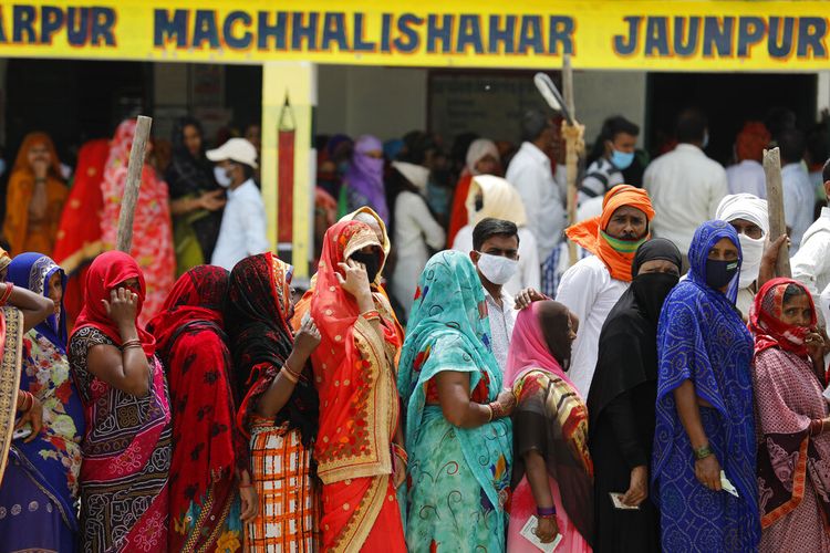 People stand in queues to cast their votes during local elections in Kunvarpur village in the northern Indian state of Uttar Pradesh, Thursday, April 15, 2021. India reported more than 200,000 new coronavirus cases, skyrocketing past 14 million overall as an intensifying outbreak puts a grim weight on its fragile health care system. (AP Photo/Rajesh Kumar Singh)