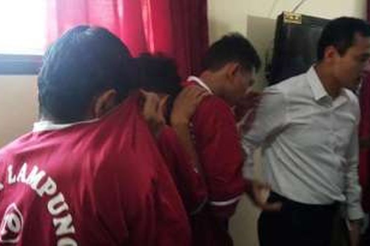 Petugas Polda Lampung membawa tersangka jual beli janin untuk tumbal pesugihan, Senin (11/4/2016). 
