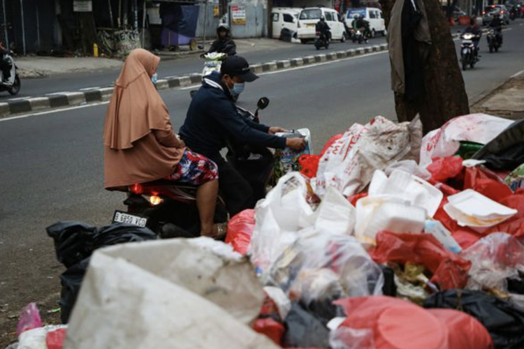 Warga membuang sampah di pinggir Jalan HOS Cokroaminoto, Larangan, Kota Tangerang, Banten, Selasa (25/4/2023). 