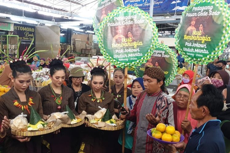 Para seniman dan pedagang Pasar Gede Solo ikut menggelar acara tumpengan dan sajian buah-buahan ikut berbahagia Presiden Jokowi ngunduh mantu Kaesang Pangarep dan Erina Gudono di pintu utama masuk Pasar Gede Solo, Jawa Tengah, Selasa (6/12/2022).