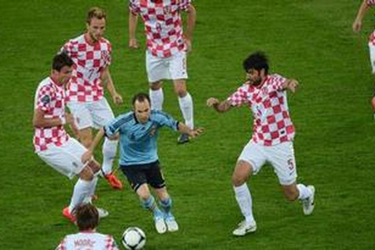 Butuh enam pemain Kroasia untuk menahan laju gelandang Spanyol, Andres Iniesta (biru), pada pertandingan yang berlangsung di Stadion PGE Arena Gdansk, 18 Juni 2012.
