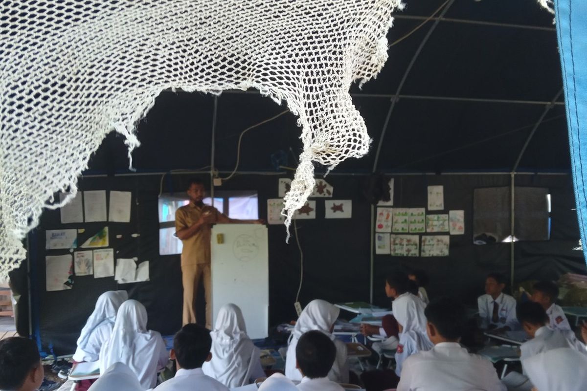 Murid SDN Cugenang, Kabupaten Cianjur, Jawa Barat ini masih belajar di tenda darurat, Senin (20/11/2023). Mereka terpaksa menjalani KBM dengan kondisi tak nyaman karena bangunan sekolah mereka yang rusak akibat gempa tahun lalu tak kunjung diperbaiki.