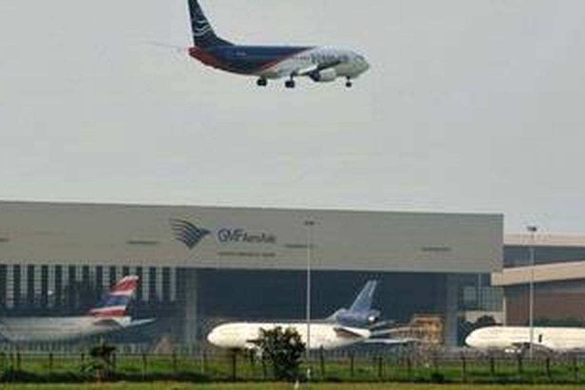 A plane flies over a Garuda Indonesia facility at Jakarta International Airport Soekarno-Hatta, in Tanggerang, on July 28, 2011. Garuda Indonesia pilots called off a 24-hour strike July 28 after receiving assurances that their concerns over pay will be addressed, union officials said.