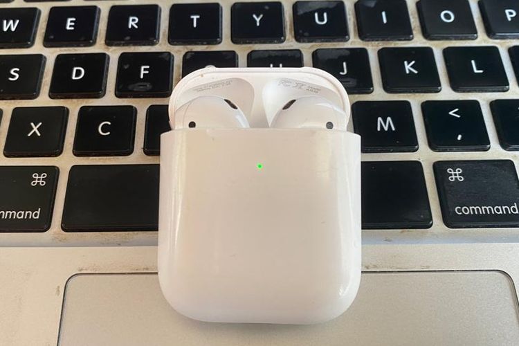 Tampilan tutup wadah AirPods yang terbuka lampu indikator berwarna hijau dan siap untuk dihubungkan dengan perangkat Apple.