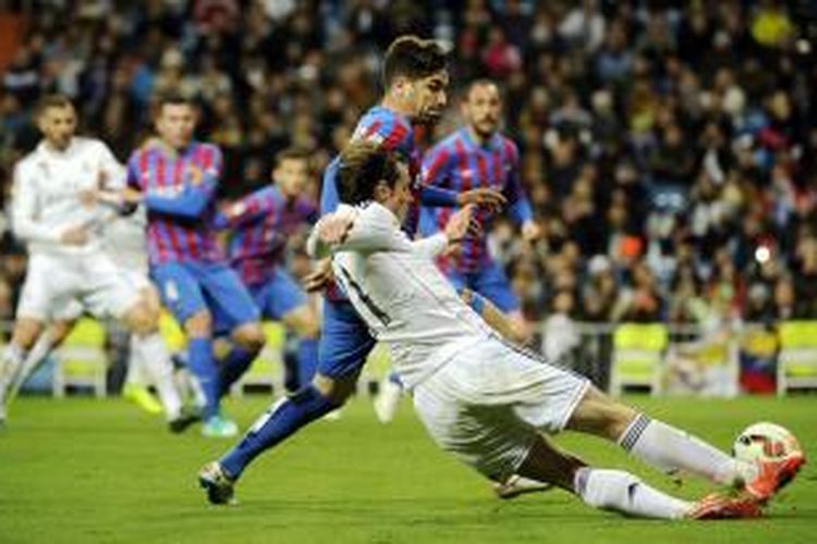 Pemain sayap Real Madrid Gareth Bale (kanan) berebut bola dengan bek Levante Tono Garcia, pada pertandingan Primera Division, di Santiago Bernabeu, Minggu (15/3/2015). Madrid memenangi laga itu dengan skor 2-0, berkat gol Bale pada menit ke-18 dan ke-40.