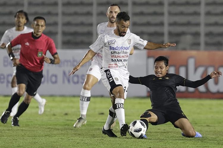 Evan Dimas (kanan) berduel dengan Diego Assiss pada laga ui coba Timnas U23 Indonesia vs Bali United di Stadion Madya Senayan, Jakarta, pada Minggu (7/3/2021) malam WIB.
