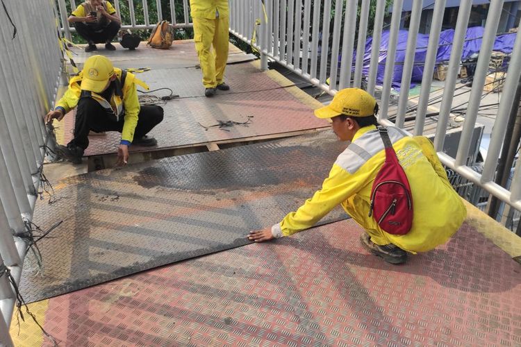 Petugas Dinas Bina Marga Bidang Prasarana dan Sarana Utilitas Kota (PSUK) DKI Jakarta melakukan perbaikan di jembatan penyeberangan orang (JPO) Jalan Daan Mogot, Jakarta Barat, Jumat (30/6/2023). 