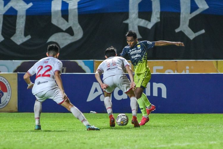 Aksi pemain Persib Bandung Frets Butuan yang hendak melepaskan diri dari kawalan dua pemain Persis Solo (putih) dalam laga pekan ke-32 Liga 1 2022-2023, di Stadion Pakansari, Cibinong, Kabupaten Bogor, Selasa (4/4/2023).