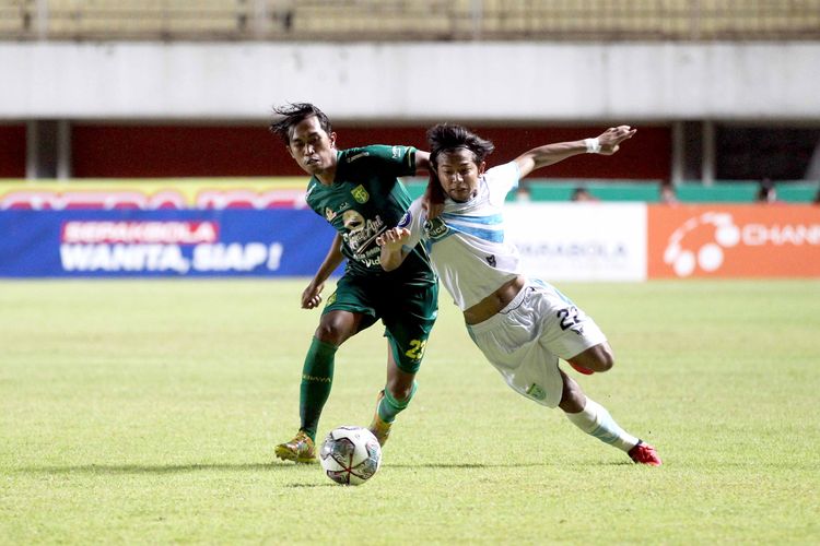 Pemain Persela Lamongan Riyatno Abiyoso ditempel ketat pemain Persebaya Surabaya Ady Setiawan pada pekan ke 8 Liga 1 2021 yang berakhir dengan skor 1-1 di Stadion Maguwoharjo Sleman, Kamis (21/10/2021) malam.
