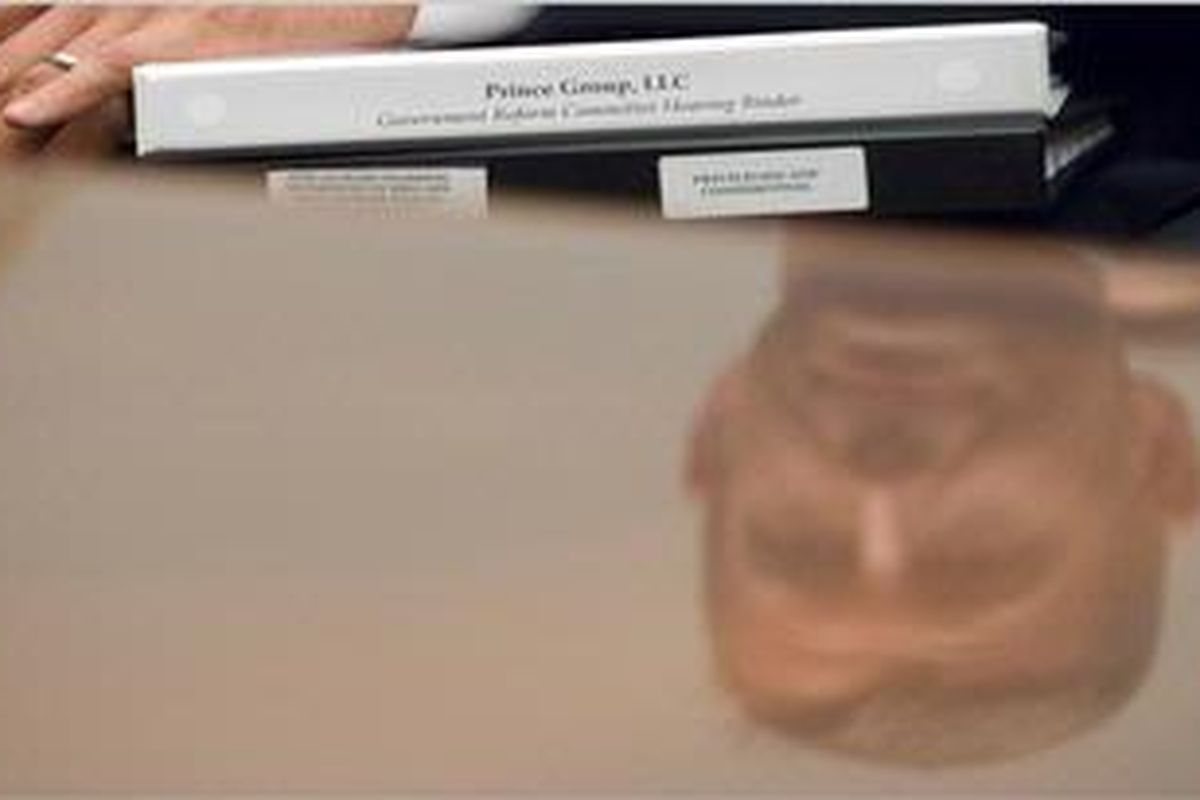 Erik Prince, chief executive officer of the company formerly known as Blackwater, is seen reflected in the witness table before he testified at a House Oversight and Government Reform Committee hearing on security contractors in Washington on October 2, 2007 