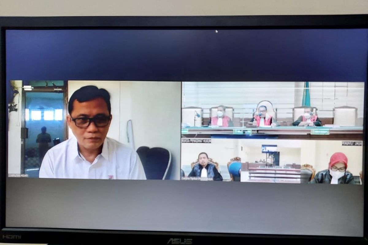 SIMAK PUTUSAN—Terdakwa kasus korupsi upah THL PDAM Kota Madiun, Sandi Kunariyanto menyimak putusan yang disampaikan Majelis Hakim Pengadilan Negeri Tindak Pidana Korupsi Surabaya secara daring, Jumat (24/6/2022). Majelis hakim memvonis Sandi terbukti bersalah dan menghukum pidana 1,5 tahun penjara. 