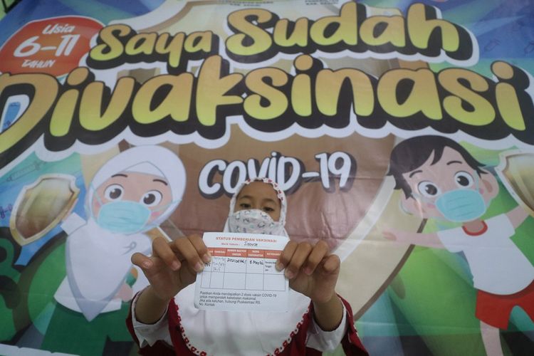 Seorang anak memperlihatkan kartu vaksinasi saat peluncuran vaksinasi COVID-19 untuk anak usia 6-11 tahun di Madrasah Ibtidaiyah Negeri 2 Kediri, Jawa Timur, Senin (20/12/2021). Vaksinasi COVID-19 bagi anak usia 6-11 tahun mulai dilaksanakan di Kabupaten Kediri dengan target 143 ribu anak dalam jangka waktu tiga bulan. ANTARA FOTO/Prasetia Fauzani/hp.