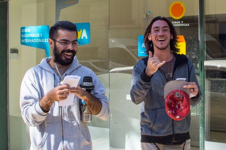 Dua orang pria tersenyum lebar setelah mendaftarkan diri sebagai konsumen ganja di sebuah kantor pos di Montevideo, Uruguay, Selasa (2/5/2017).