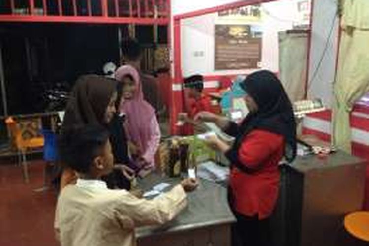 Pengunjung menyerahkan secarik kertas Kartu Doa sebagai alat pembayaran menu berbuka puasa kepada pelayan Soto Kauman Express, Sawangan, Depok, Rabu (8/6/2016). Kartu Doa adalah alat pembayaran dalam program 