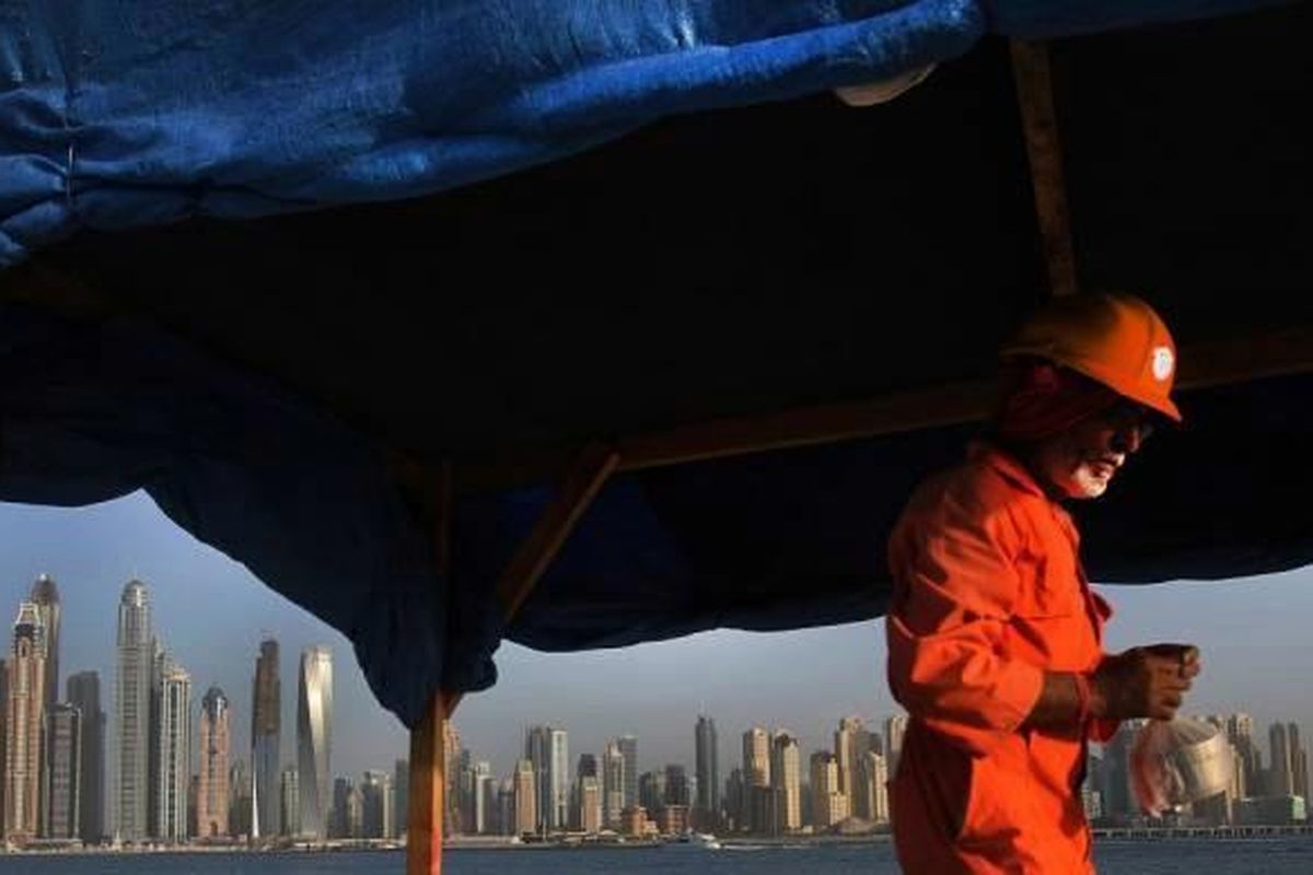 Seorang buruh membawa kotak makan saat ia meninggalkan lokasi konstruksi di Palm Jumeirah, Distrik Marina, Dubai, Uni Emirat Arab, 22 September 2015.