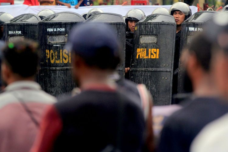 Sejumlah polisi bersiaga saat massa pendukung Gubernur Papua Lukas Enembe berunjuk rasa menolak penetapan tersangka Gubernur Papua Lukas Enembe oleh Komisi Pemberantasan Korupsi (KPK) di Titik Nol, Taman Imbi, Kota Jayapura, Papua, Selasa (20/9/2022). Polri mengerahkan sekitar 2.000 personel dalam mengamankan aksi dukungan kepada Lukas Enembe yang ditetapkan oleh KPK sebagai tersangka gratifikasi tersebut. ANTARA FOTO/Gusti Tanati/app/foc.