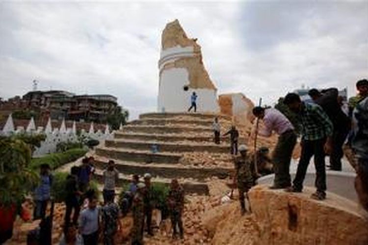 Warga bahu-membahu menyingkirkan puing-puing Menara Dharahara yang ambruk akibat gempa 7,9 SR di Nepal utnuk mencari korban yang mungkin tertimbun.