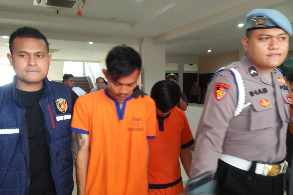 Kedua pelaku pembunuhan dan perampokan pria di Menganti (tengah), menuju tempat rilis ungkap kasus di halaman Mapolres Gresik, Jawa Timur, Rabu (6/12/2023).