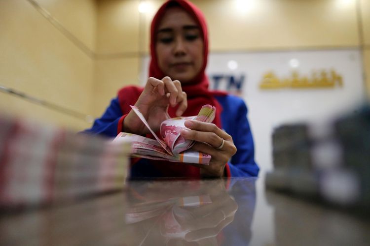 Ilustrasi. Pegawai bank menghitung uang kertas rupiah di Banking Hall BTN Syariah di kawasan Harmoni, Jakarta, Kamis (30/3/2017).