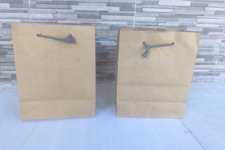 Kantong kertas berisi menu MBG yang dibawa pulang siswa SDN 1 kangenan dari SPPG Dapur Kangenan, Pamekasan, Jumat (17/10/2025)