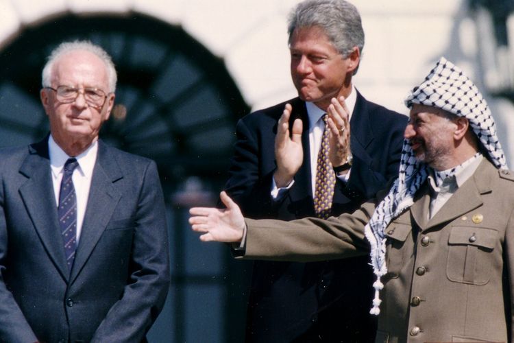 Perdana Menteri Israel Yitzhak Rabin (kiri), Presiden Amerika Serikat Bill Clinton (tengah) dan Ketua Organisasi Pembebasan Palestina (PLO) Mahmoud Abbas (kanan) setelah menandatangani Perjanjian Oslo pada September 1993 di Amerika Serikat.