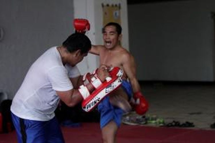 Atlet pelatnas muay thai kelas 64 kilogram, Khaeril Anas (kanan), melakukan tendangan atas pada sesi latihan rutin di Pintu XII Gelora Bung Karno, Senayan, Jakarta, Rabu (17/7/2013)