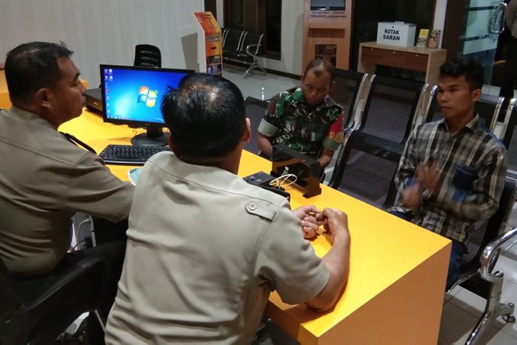 Tersangka AB ketika diserahkan ke Polres Prabumulih, Sumatera Selatan oleh intel Kodim 0404/ Muara Enim lantaran diduga telah menghina instansi TNI dengan menuliskan status di media sosial Facebook, Senin (17/12/2018).