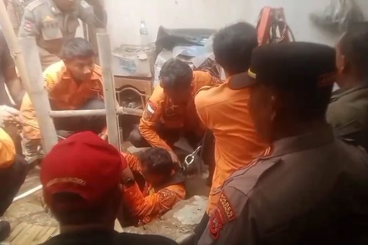 Petugas Damkar bersama BPBD serta dibantu dari pihak kepolisian dan warga setempat saat masuk ke dalam sumur untuk mengangkat tubuh kakek Warta (71) yang tewas tenggelam ketika hendak menyelamatkan cucunya yang tercubur ke dalam sumur di Desa waringin, Kecamatan Palasah, Kabupaten Majalengka, Jawa Barat, Selasa (21/10/2025).