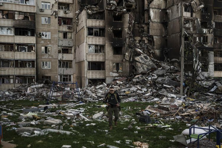 Seorang prajurit Ukraina berjalan di tengah puing-puing sebuah bangunan yang rusak berat oleh beberapa pemboman Rusia di dekat garis depan di Kharkiv, Ukraina, Senin, 25 April 2022. 