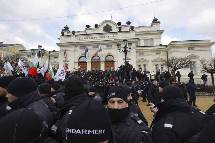 Petugas polisi berbaris ketika mereka mencoba untuk menjauhkan pengunjuk rasa dari gedung Parlemen Bulgaria di Sofia, Rabu, 12 Januari 2022. 
