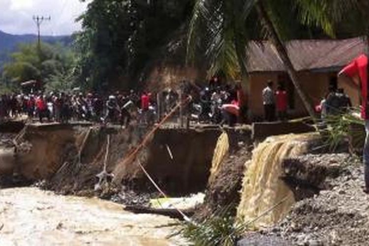 Warga mencoba melintas di jalanan yang badan jalannya amblas di Kecamatan Tangse Kabupaten PIdie. Badan jalan ini amblas akibat banjir yang kembali melanda Tangse sejak Kamis petang kemarin.*****K12-11