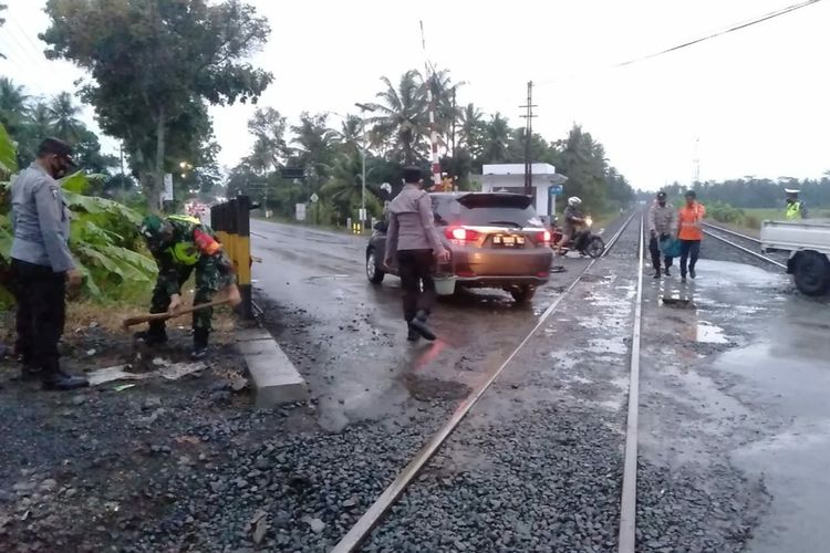 Personel TNI dan Polri menambal jalan yang berlubang di perlintasan KA Kutowinangun, Kabupaten Kebumen, Jawa Tengah, Selasa (14/9/2021).
