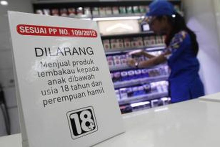 Petugas kasir memasang tanda larangan anak di bawah umur membeli rokok, di Indomaret, Jakarta Pusat, Selasa (3/11/2015). Program tersebut ditujukan untuk meningkatkan kesadaran masyarakat akan pelarangan pembelian produk tembakau oleh anak-anak di bawah 18 tahun.
