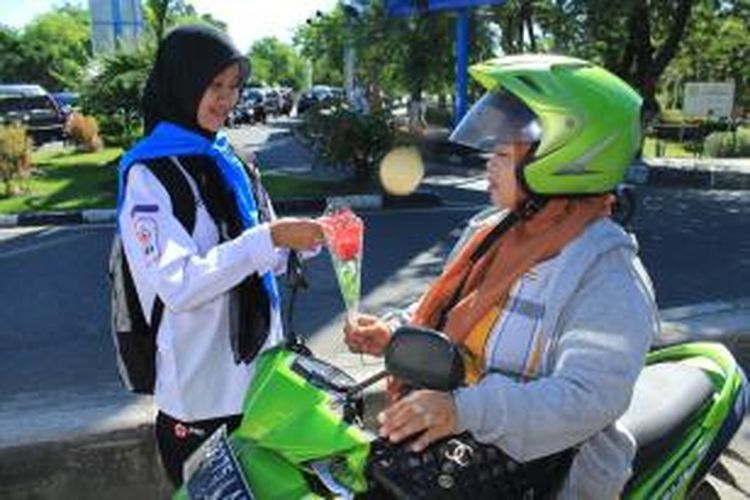 Seorang relawan membagikan pesan kemanusiaan peduli Thalassemia dan menyerahkan setangkai bunga kepada pengguna jalan di Simpang Lima Banda Aceh Kamis (7/5/2015) dalam rangka memperingati Hari Thalassemia Internasional di Banda Aceh.