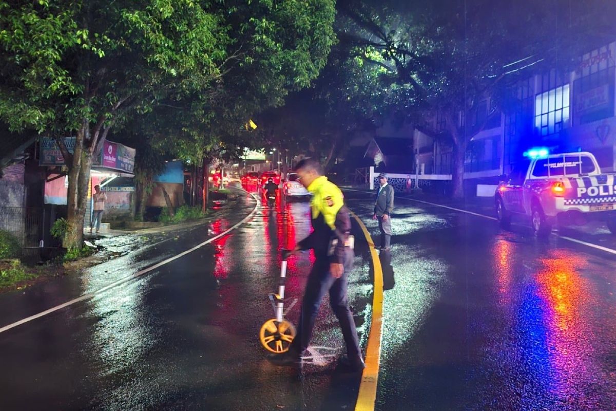 Kepolisian melakukan olah tempat kejadian perkara (TKP) di lokasi penyeberang jalan yang ditabrak angkot berwarna biru di Jalan Raya Puncak Bogor, Jawa Barat, Jumat (23/1/2026) malam.