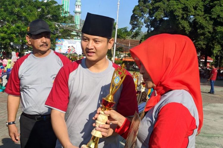 Plt. Bupati Trenggalek, Mochammad Nur Arifin, menyerahkan piala kepada pemenang lomba PAUD, Jumat (12/5/2018)