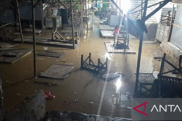 Banjir akibat luapan sungai mulai menggenangi lapak pedagang di Pasar Parteker, Pamekasan, Jawa Timur, Kamis (10/3/2022) malam. 