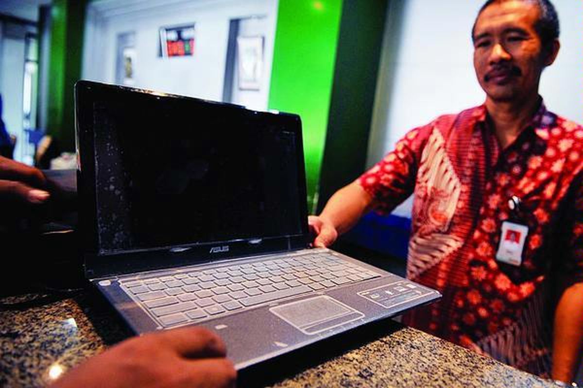 Petugas menerima komputer jinjing (laptop) yang akan digadaikan di Pegadaian Senen, Jakarta Pusat, Jumat (10/8). Selain mendapatkan uang, barang yang digadaikan juga lebih aman ketimbang ditinggal di rumah saat mudik Lebaran.