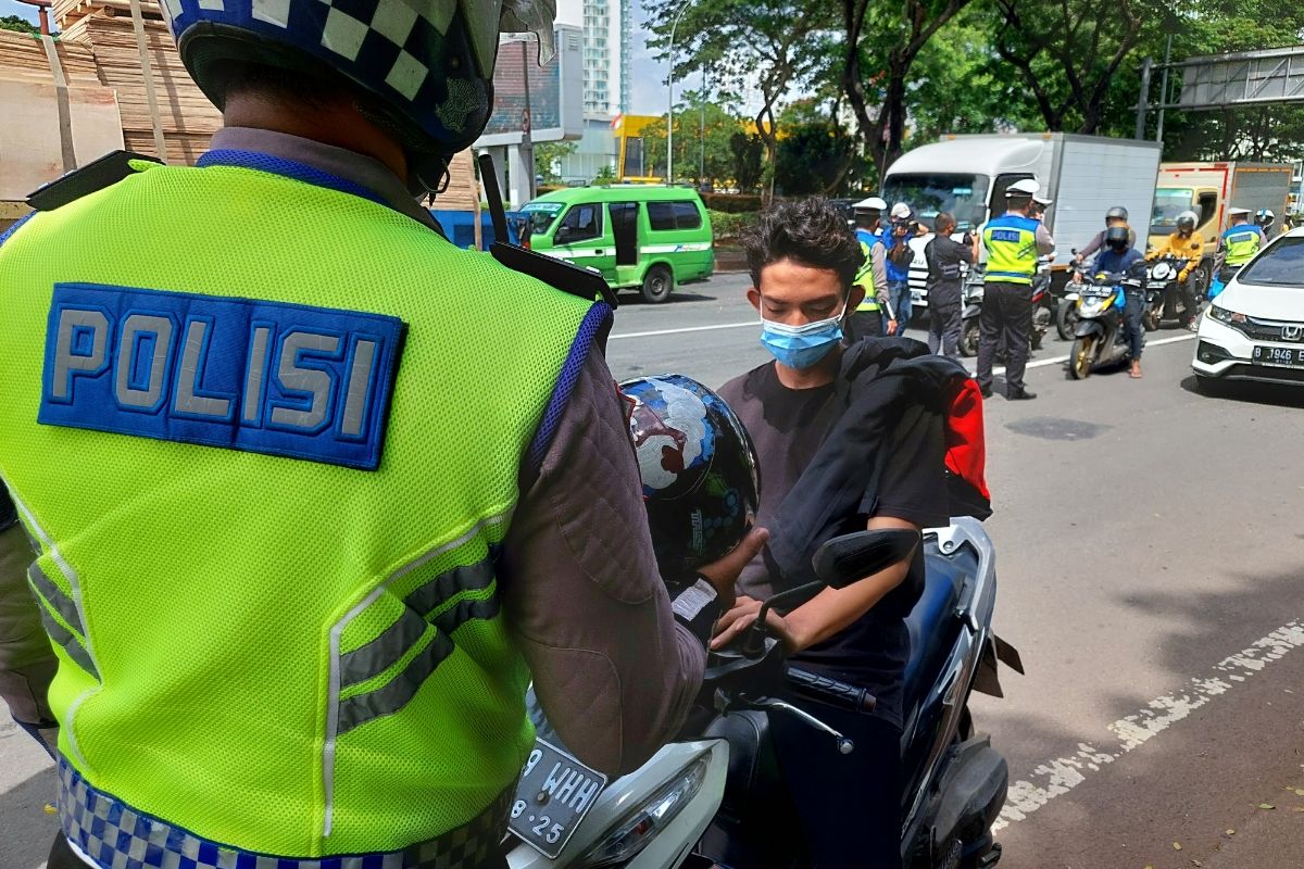 Seorang pengendara motor yang didapati tak menggunakan helm saat berkendara di Jalan Pahlawan Seribu, Serpong, Tangsel, Selasa (16/11/2021).