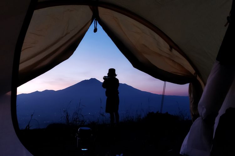 Seorang wisatawan tengah menikmati pemandangan Gunung Gede Pangrango detik-detik menjelang momen golden sunrise yang dilihat dari Desa Pasirjaya, Kecamatan Cigombong, Kabupaten Bogor pada Kamis (27/5/2021).