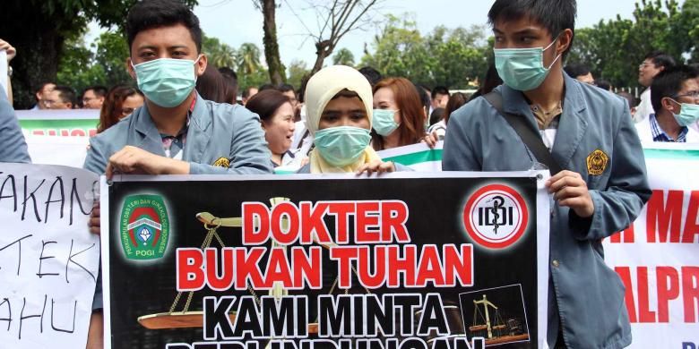 Salah satu spanduk yang dibawa para dokter ketika menggelar aksi keprihatinan atas ditahannya rekan sejawat mereka di Manado.