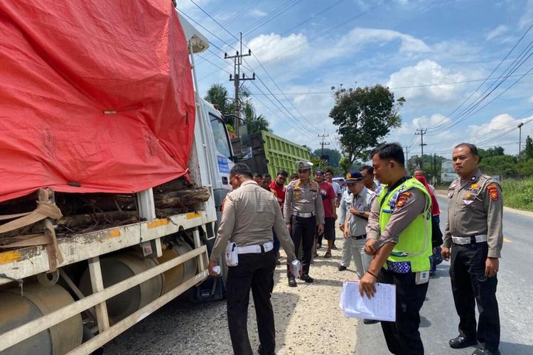 Petugas kepolisian melakukan olah TKP pada kasus kecelakaan lalu lintas yang menewaskan pengendara becak motor di Jalan Pasir Putih, Kecamatan Siak Hulu, Kabupaten Kampar, Riau, Selasa (16/5/2023).
