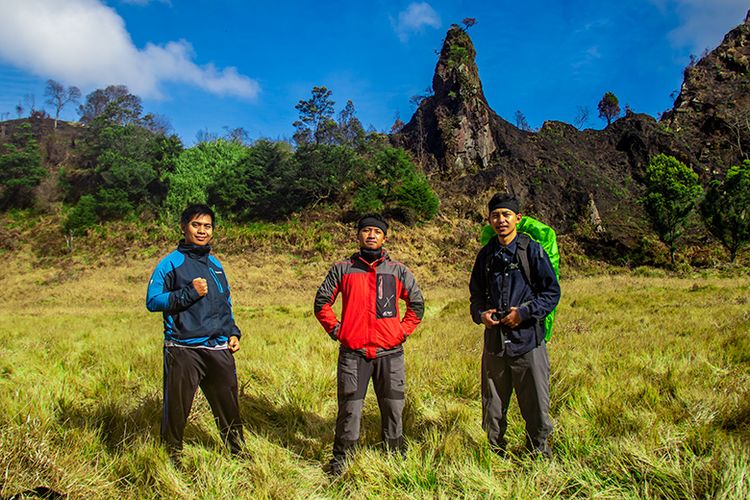 Pendaki Gunung Pakuwaja berfoto dengan latar belakang Batu Paku Jawa di Gunung Pakuwaja.